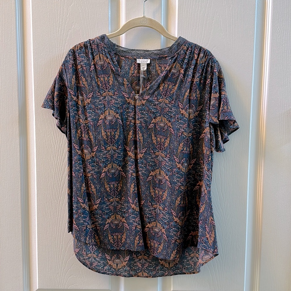 Blue floral flutter sleeve top. Hi/low hem. Lace collar. Hinge